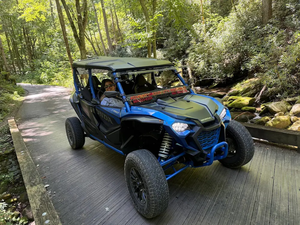 Blue off-road UTV on wooden bridge